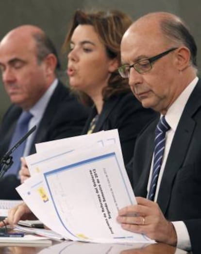 La vicepresidenta del Gobierno, Soraya Sáenz de Santamaría, junto a los ministros de Economía, Luis de Guindos (izda), y Hacienda, Cristóbal Montoro, durante la rueda de prensa que ofrecieron al término de la reunión del Consejo de Ministros, hoy en el Palacio de la Moncloa.