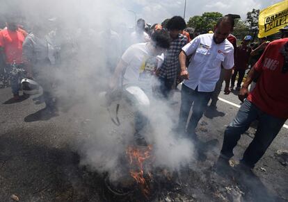 El diputado de la oposición, Freddy Guevara (c) -con una camiseta del encarcelado Leopoldo López- trata de provocar un fuego durante la protesta en Caracas.