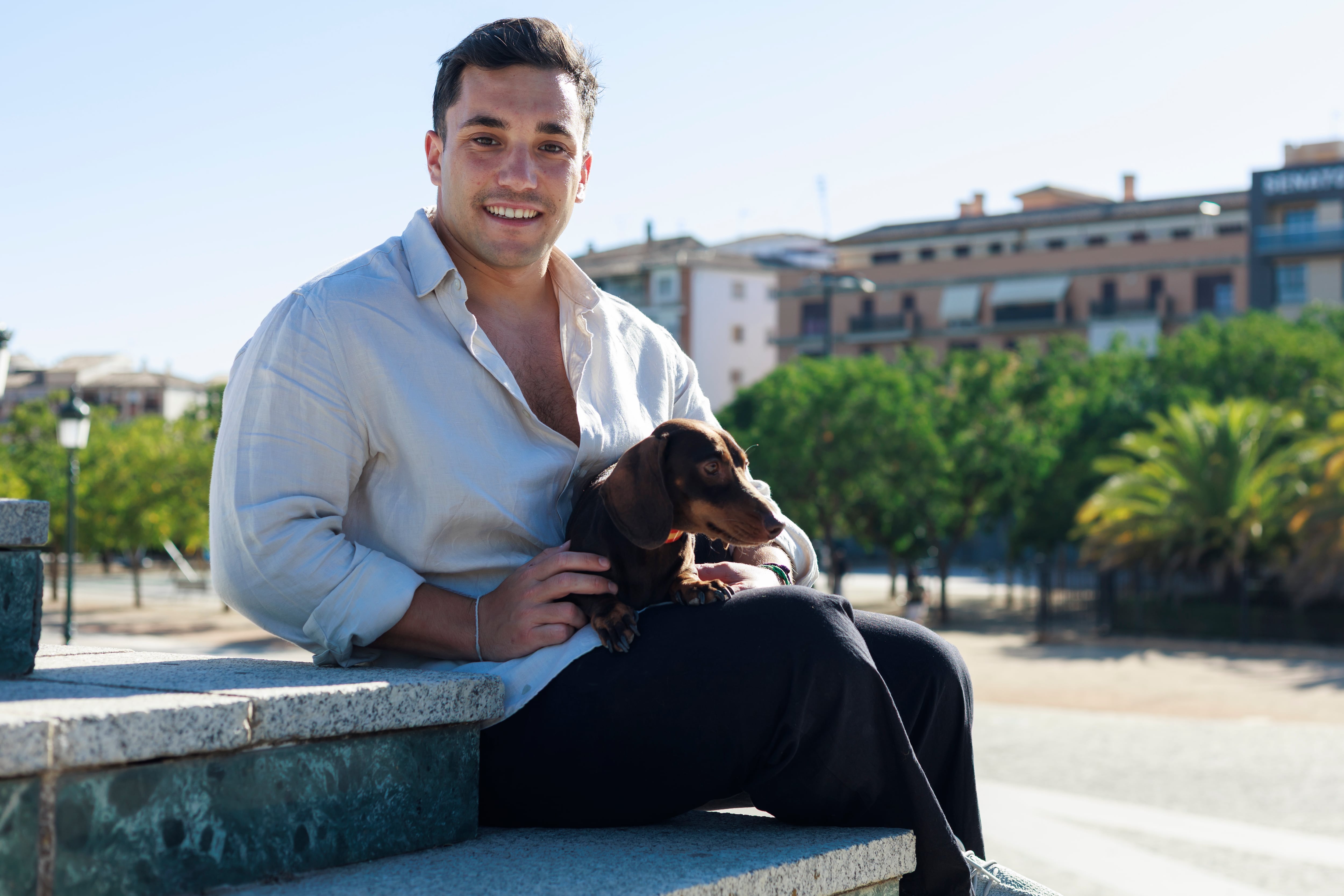 Manuel Piñar Ibáñez, de 29 años, posa junto a Rufo, su perro salchicha de cinco años, en la ciudad de Granada, el 28 de agosto de 2025.