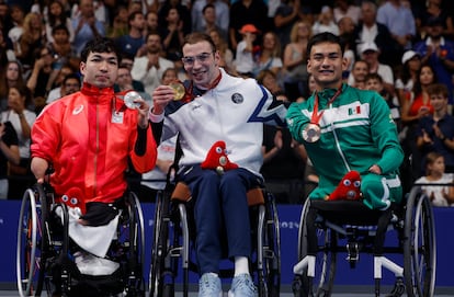 Ángel de Jesús Camacho en el podio de natación junto a competidores de Israel y Japón.