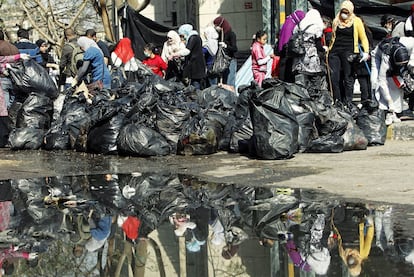 Un grupo de voluntarios recoge bolsas de basura en la plaza de la Liberación de El Cairo.