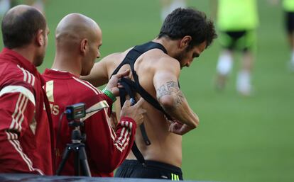 Cesc se pone un artilugio que sirve para el seguimiento del entrenamiento por el preparador fisico