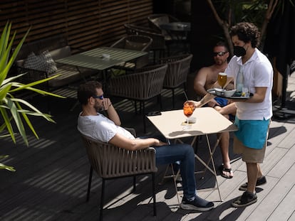 Un camarero sirve unas bebidas a clientes en un hotel de Barcelona.