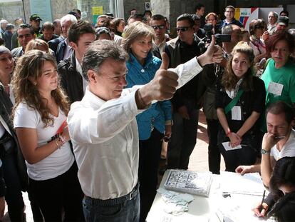 El candidato oficialista Juan Manuel Santos, ganador de la primera vuelta, hace el signo de la victoria tras depositar su voto en Bogotá.
