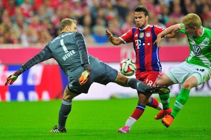 Bernat y Neuer pugnan por el balón, ante la mirada de De Bruyne.