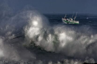 Un barco pesquero sale del puerto de A Coruña (a la altura de la Torre de Hércules), pese a que está activada la alerta roja en todo el litoral gallego por mar de fondo del noroeste.