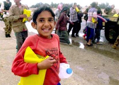 Un niño muestra la ayuda humanitaria recibida en la localidad sureña de Um Qsar.