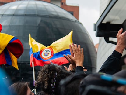 Personas ondean una bandera de Colombia.