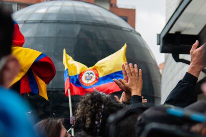 Personas ondean una bandera de Colombia.