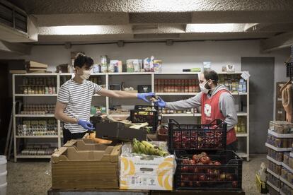 La ONG de Vei a vei organiza una red solidaria de distribuición de comida a personas con pocos recursos en el Barrio de Sant Antoni, en Barcelona. En la imagen Alvaro y Pol, dos voluntarios de la ONG, organizan el almacén en la sede de la Calle Rocafort.
