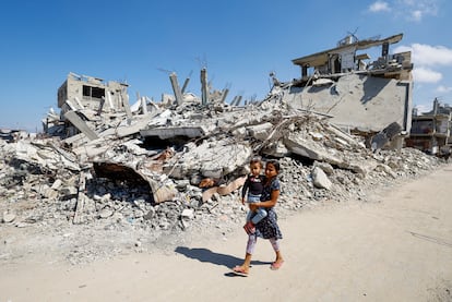 Una niña palestina con un niño en brazos en Khan Younis, al sur de la Franja de Gaza, este 10 de octubre de 2024.