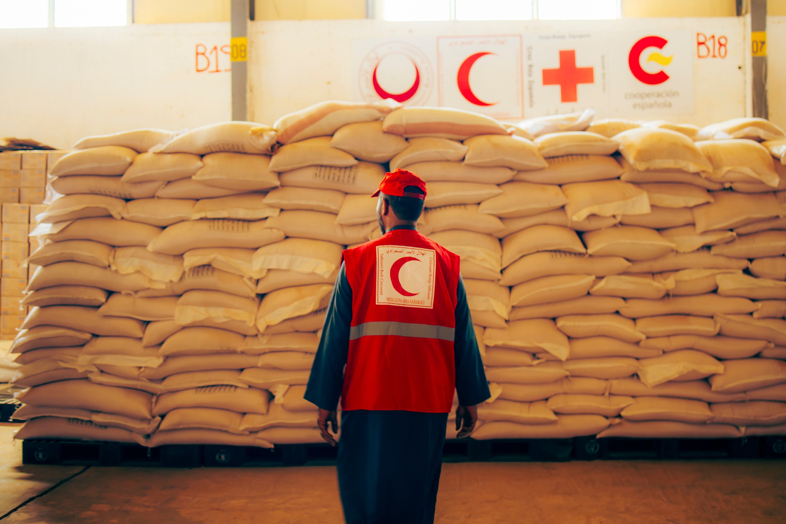 Un trabajador de la Media Luna Roja Saharaui en Rabuni, el complejo administrativo de los campamentos de refugiados en Tinduf (Argelia), observa las escasas existencias de alimentos almacenados, que apenas dan para mantener las distribuciones de comida en junio. 