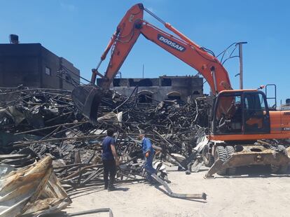 Trabajadores de la fábrica de colchones Foamco, destruida en un ataque israelí, retiran escombros, el domingo en Gaza.