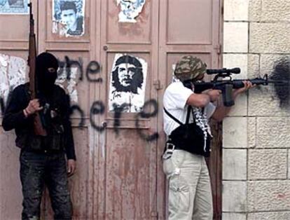Dos palestinos toman una posición en la localidad cisjordana de Beit Jala para disparar contra soldados israelíes.