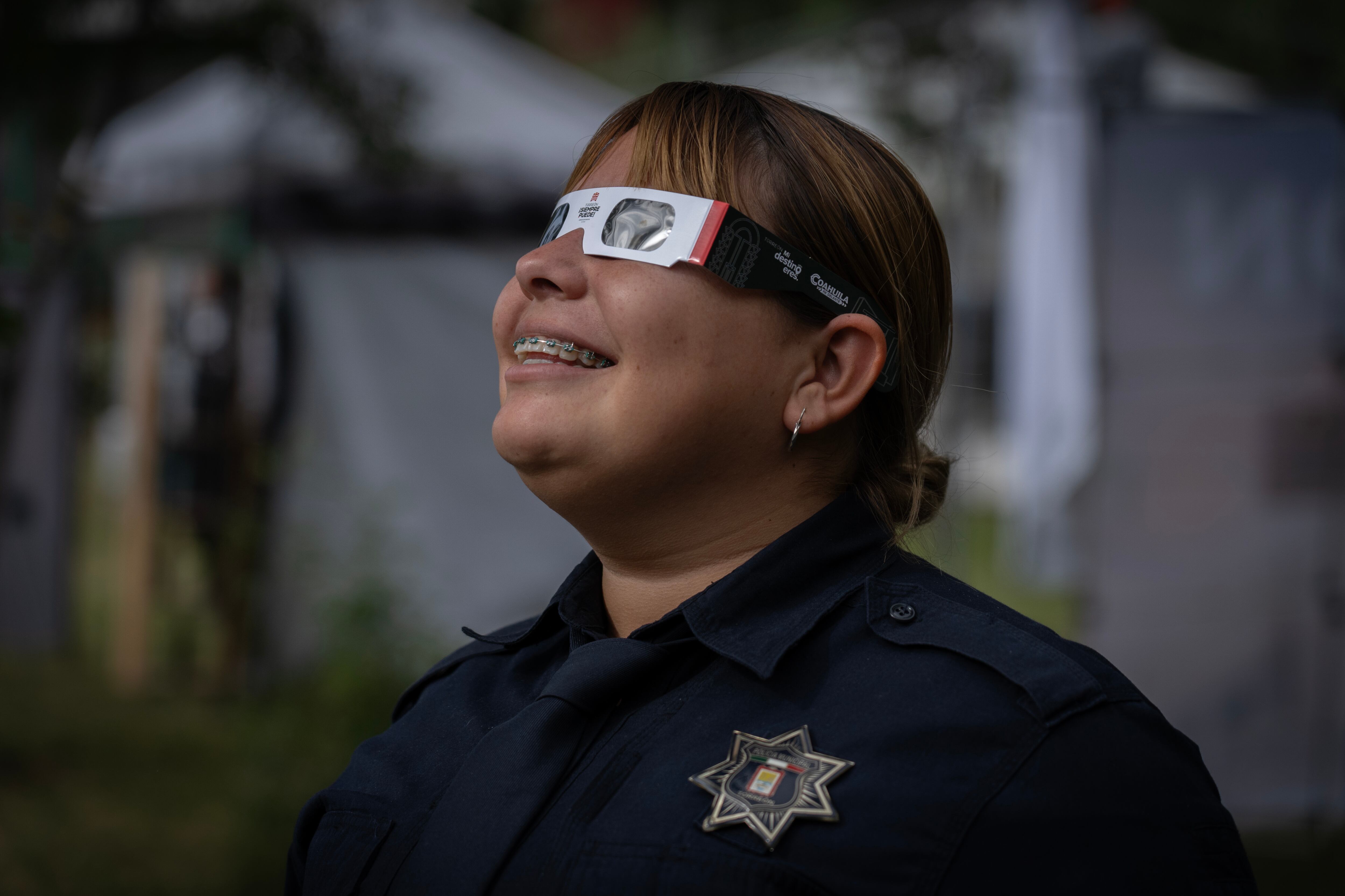 Una policía observa el Eclipse Solar en Torreón, Coahuila. 8 de abril 2024.