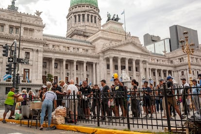 A group of unemployed people queue in front of the National Congress, to receive donated food from NGOs, in Buenos Aires on February 29, 2024.