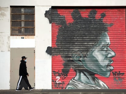 Una persona camina al lado de un grafiti en la ciudad francesa de Bayona.