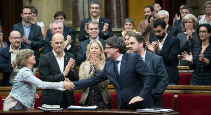 Diputados aplauden al presidente Puigdemont tras superar en votación la cuestión de confianza.
