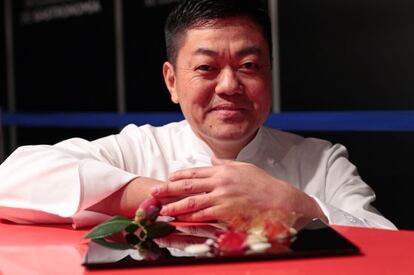 El chef Yoshiro Narisawa, con uno de sus platos basados en alimentos fermentados, como el arroz o la flor de camelia japonesa.