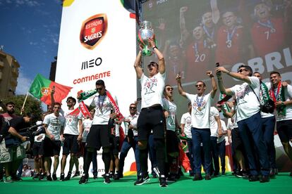 El jugador portugues Cristiano Ronaldo sujetando el trofeo de la Eurocopa durante la celebración del título.