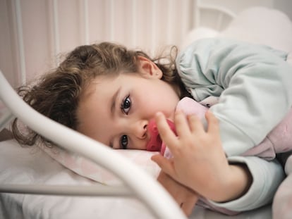 Una niña duerme descansa en su cama.