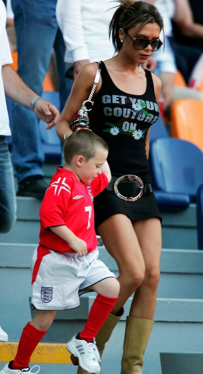 En la Euro UEFA de 2004, en Portugal. Tras el fiasco de su carrera musical en solitario, Victoria Beckham decidió centrarse en su vida como madre y mujer de futbolista. Ella ha sido pionera del fenómeno WAGs –de las siglas en inglés Wifes and Girlfriends’ Soccers– dedicándose a llenar las gradas de los estadios de medio mundo con las últimas tendencias. Las de 2004 incluían todo lo que se ve en esta foto: minifalda con cinturón por debajo de la cadera y maxi hebilla, camiseta ajustada con mensaje, botas altas y bolso de marca, en este caso, de Dior.