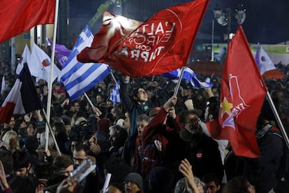 Seguidores ondean banderas del partido Syriza y de Grecia durante las celebraciones en el exterior de la sede de la Universidad de Atenas.