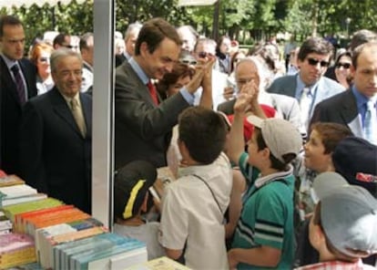 José Luis Rodríguez Zapatero, entre el director de la Feria, Antonio Albarrán, y la ministra Carmen Calvo, ayer en el Retiro.

 / RICARDO GUTIÉRREZ