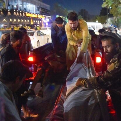 EDITORS NOTE: Graphic content / Volunteers and medical staff unload bodies from a pickup truck outside a hospital after two powerful explosions, which killed at least six people, outside the airport in Kabul on August 26, 2021. (Photo by Wakil KOHSAR / AFP)