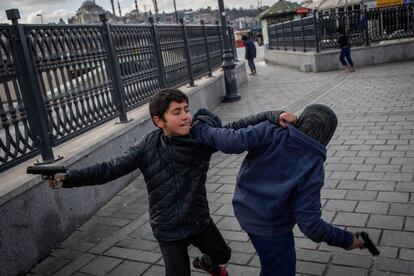 Niños refugiados sirios se divierten con una pistola de juguete en Estambul (Tuquía).