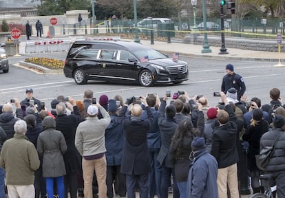 El coche fúnebre con el ataúd del expresidente George H. W. Bush deja el Capitolio ante cientos de curiosos que despiden los restos mortales.