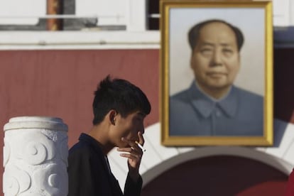 Un hombre fuma un cigarrillo delante de una imagen de Mao Zedong, este viernes en Yinchuan. 