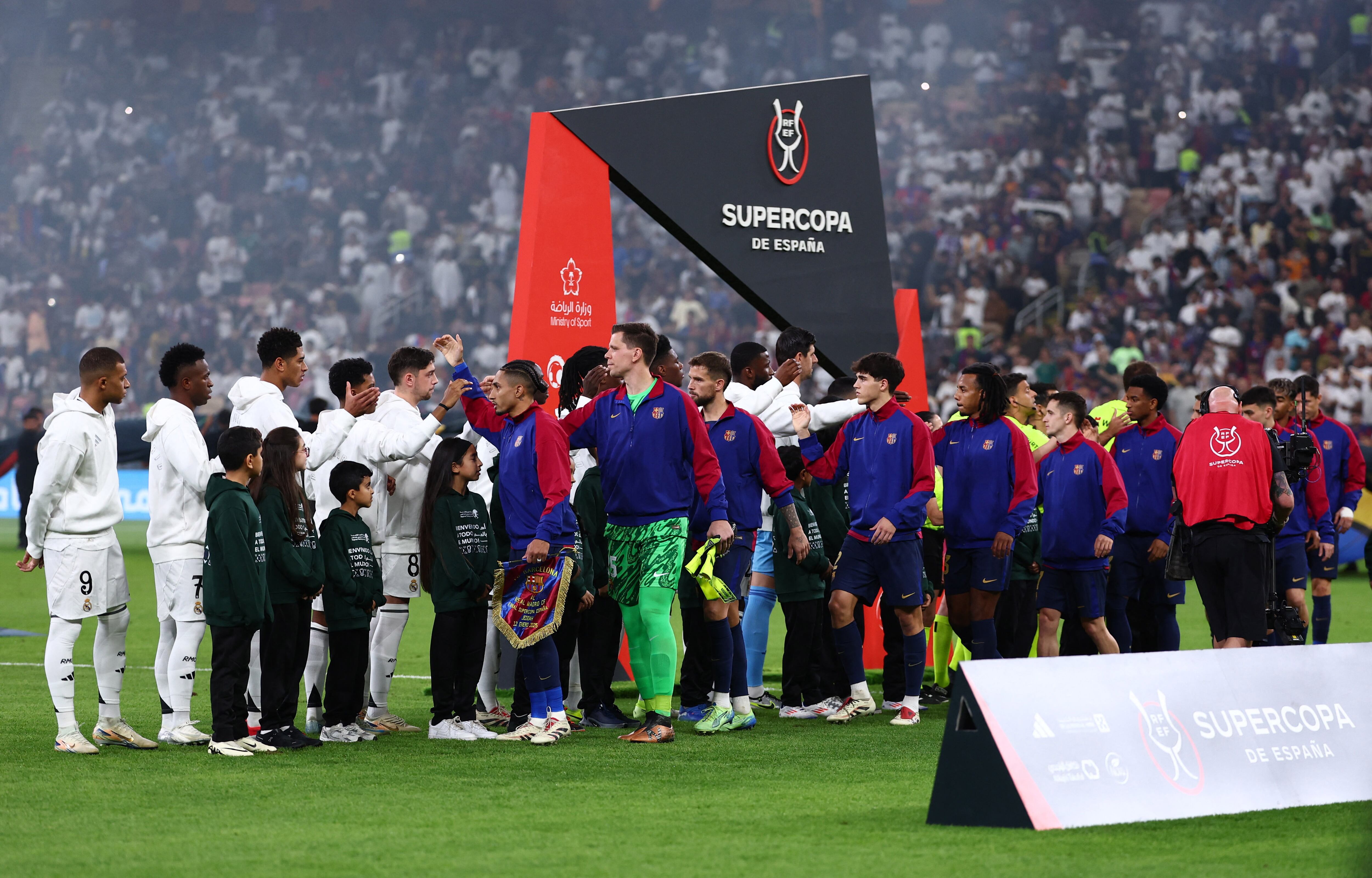 Los futbolistas del Real Madrid y del FC Barcelona se saludan antes de la final de la Supercopa de España el pasado mes de enero.