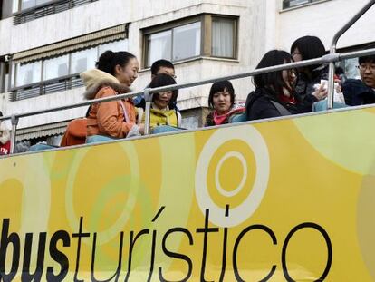 Un grupo de turistas chinos se montan en el bus turístico de la ciudad de Valladolid.