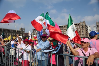 Participantes del mitin llevan banderas de México.