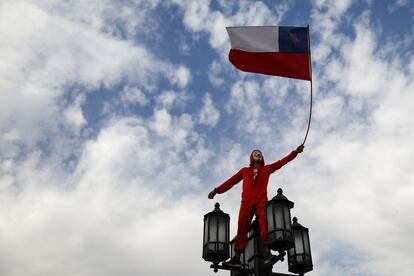 La concentración estaba convocada para las cinco de la tarde, pero desde algunas horas antes, cientos de personas comenzaron a caminar hacia el punto de encuentro por la columna principal de la ciudad: la Alameda, que luego se transforma en Providencia y Apoquindo. En la imagen, un joven disfrazado ondea una bandera de Chile durante la marcha.