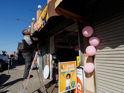 Lottery worker David Velezaqez installs a billion dollar sign above the Las Palmitas Mini Market after the small shop sold the winning ticket with all six Powerball lottery numbers in Los Angeles, California.