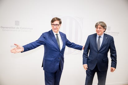 El presidente de la Generalitat, Salvador Illa, saluda al presidente de Junts per Catalunya, Carles Puigdemont, durante una reunión en Bruselas (Bélgica), este martes.