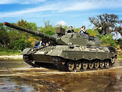 Visitantes do parque Drive Tank conduzem um tanque de guerra.