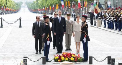 Hollande (izq) acompaña a los Reyes en la ofrenda floral, en París.