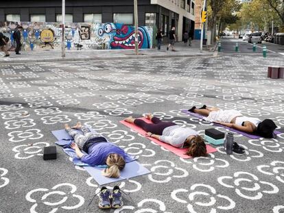 Unes veïnes practiquen ioga en una de les interseccions de la superilla.