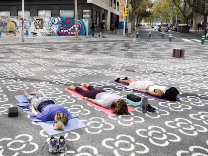 Vecinas de Poblenou practican yoga en una de las intersecciones de la 'supermanzana'.