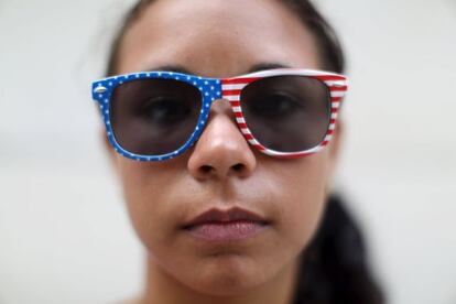 Una estudiante cuba posa en La Habana con unas gafas adornadas con la bandera de Estados Unidos.