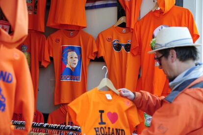 Un hombre observa las camisetas conmemorativas para la entronización del príncipe Guillermo-Alejandro en una tienda de Amsterdam (Holanda).