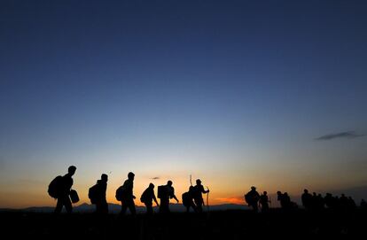 Un grupo de sirios recorre un campo en su camino hacia la frontera del norte de Grecia.