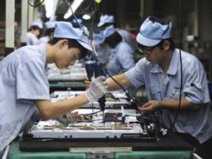 Varios operarios trabajan en una línea de montaje de televisores en una fábrica de Shenyang, en la provincia de Liaoning (China).La actividad del sector manufacturero chino cayó en abril por cuarto mes consecutivo, según un estudio publicado de la entidad bancaria HSBC. EFE/Archivo