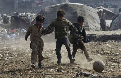 Ni&ntilde;os paquistan&iacute;es juegan a f&uacute;tbol en un barrio chabolista de Lahore.