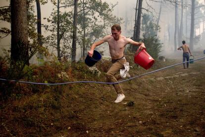 Una persona treballa en l'incendi a la zona de Zamanes, Vigo.