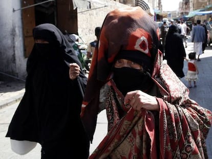 Dos mujeres caminan hoy por el mercado de la ciudad vieja en San&aacute;)