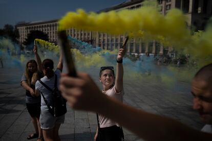 A woman holds a torch at a protest initiated by family members of captured Ukrainian soldiers by Russia in Kyiv, Ukraine, Sunday, Aug. 27, 2023.